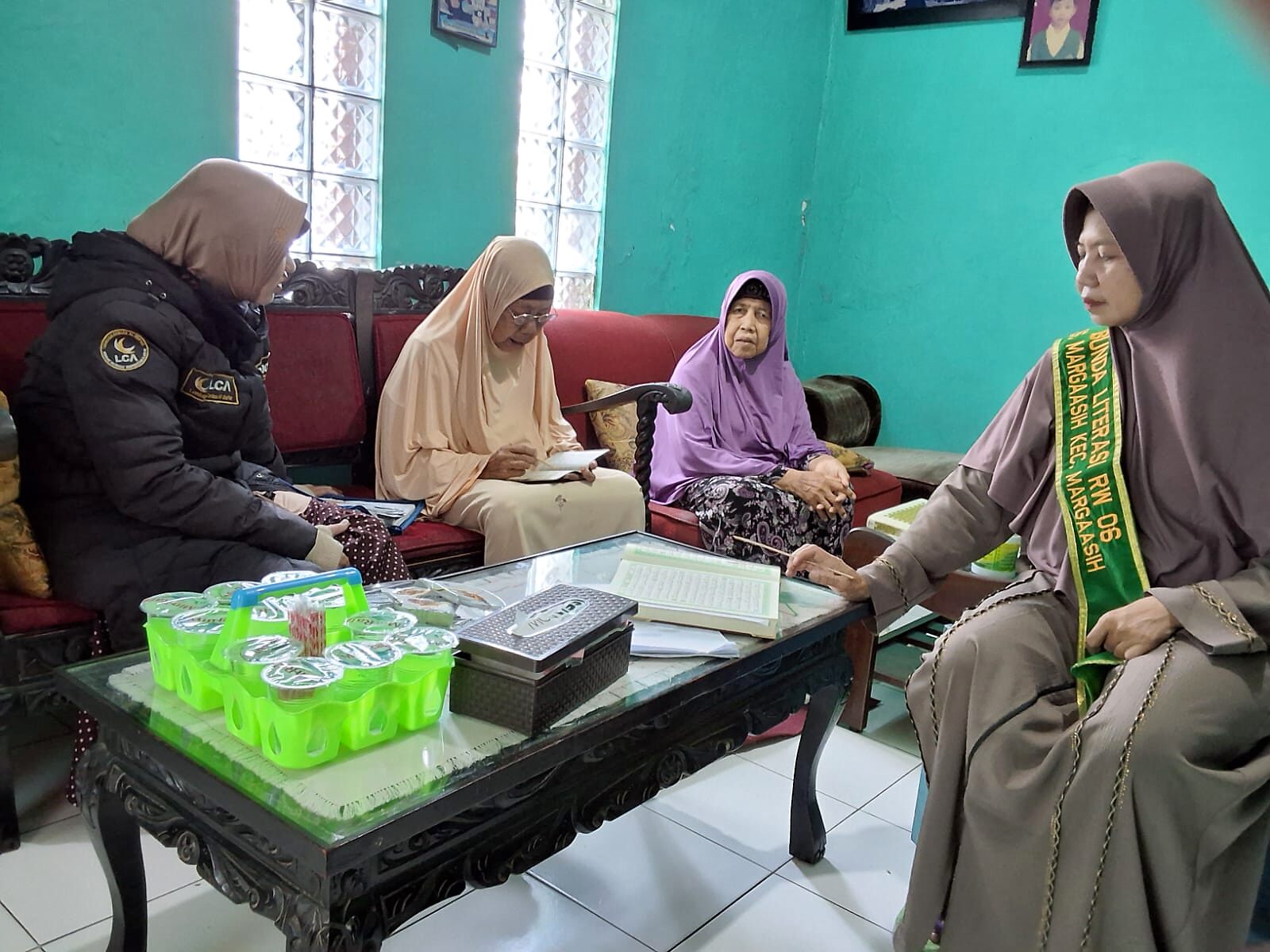 Guru Ngaji mendampingi ibu dan lansia belajar Al-Qur'an di rumah